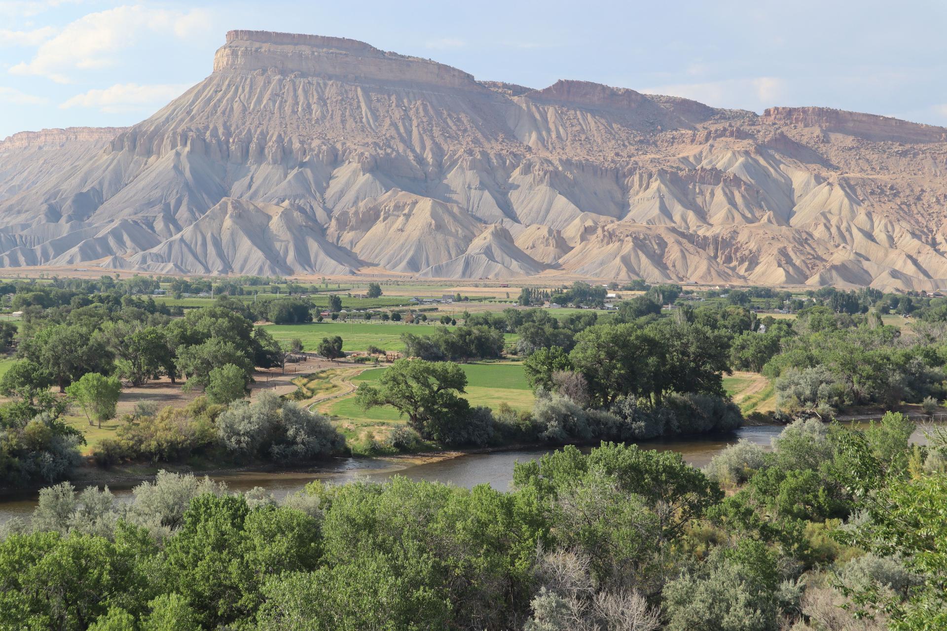 Grand Mesa with the Colorado River running through a lush valley in Grand Junction, Colorado