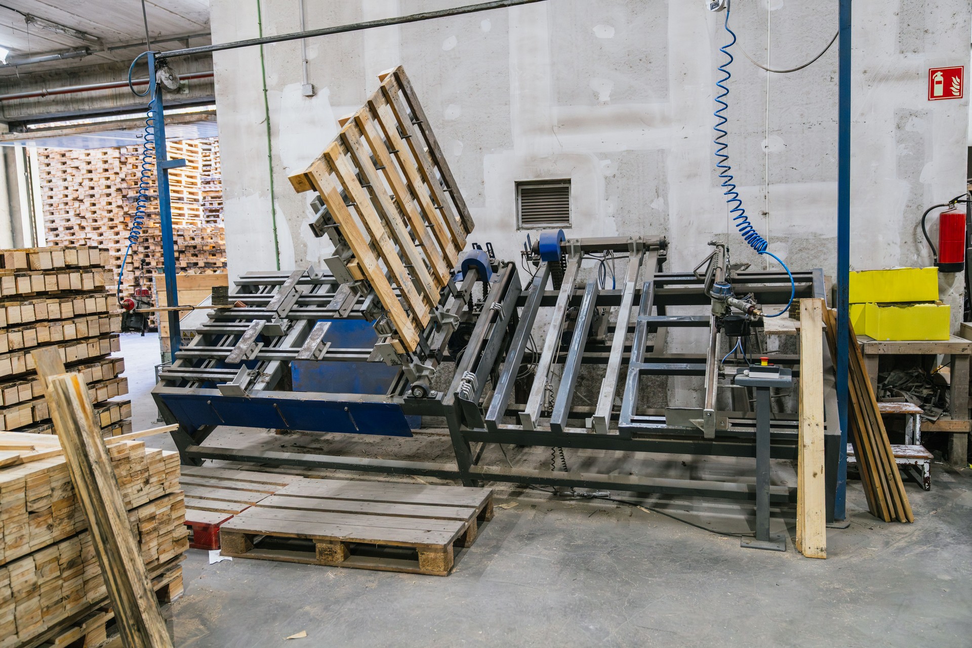 Dismantling machine processing wooden pallets in recycling factory