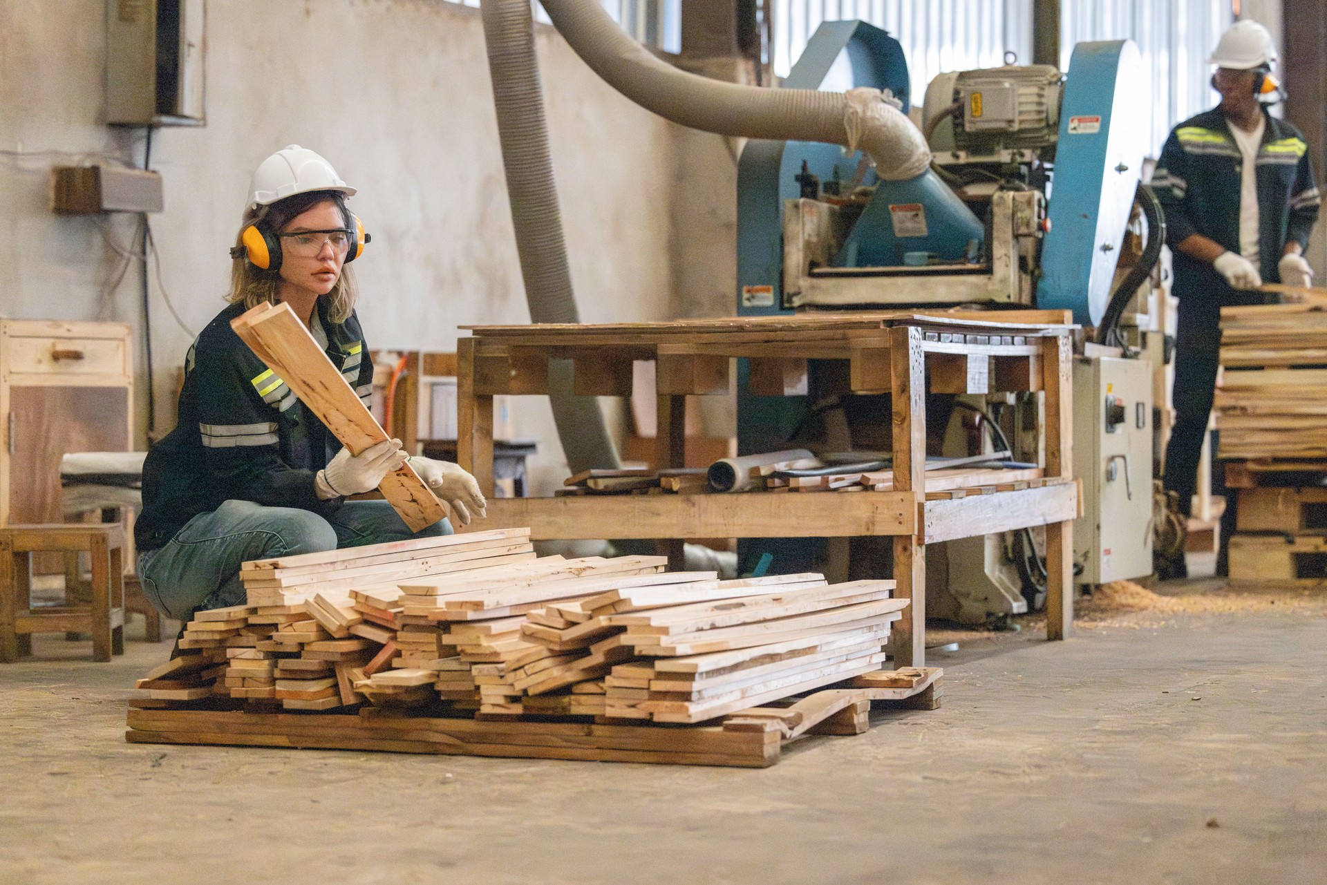 Woodworkers operate machines, tend lathes to cut, shape wood fixtures in manufacturing process